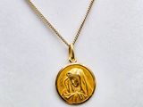 un collier plaqué or orné d'une image de la Vierge Marie