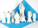 des figurines représentant un groupe de personnes vêtues de blanc sur fond bleu
