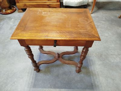 une petite table avec un tiroir, placée au milieu d'une pièce