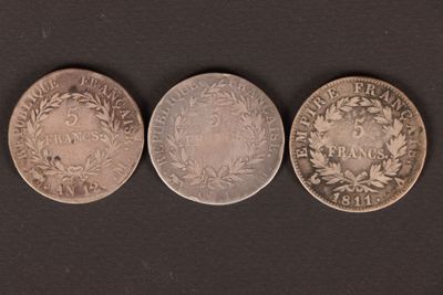 three different types of coins on a black surface