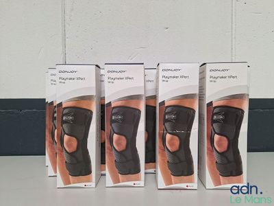 three boxes of knee braces sitting on a table in front of a wall