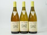 trois bouteilles de vin posées les unes à côté des autres sur une surface blanche