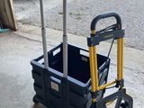 un chariot noir et jaune muni d'une poignée, posé sur le trottoir