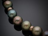 a close up of a pearl necklace on a black surface