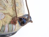 a large vase with a rope hanging from it ' s side