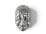 un masque argenté sur un fond blanc, arborant un sourire