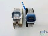 two watches sitting next to each other on a white surface