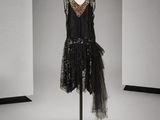 une robe noire posée sur un mannequin dans une pièce blanche