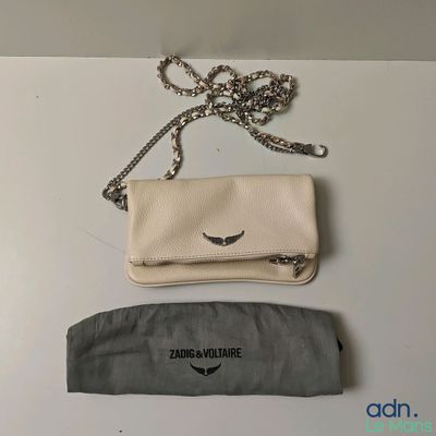a white purse and a black bag on a table