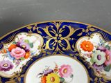 a blue and gold plate with flowers on it