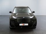 the front of a black bmw suv parked in a showroom