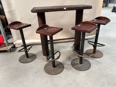 trois tabourets et une table dans une pièce aux murs blancs