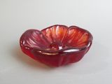 un bol en verre rouge contenant une fleur