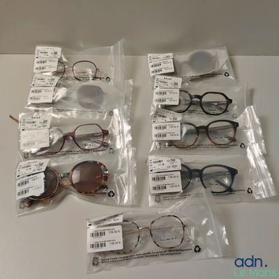 Plusieurs paires de lunettes se trouvent dans des pochettes posées sur une table