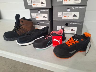several pairs of shoes are lined up on a shelf in front of boxes