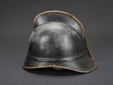 an old helmet is sitting on a table with a gray background