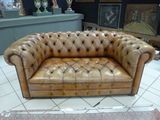 a brown leather couch that is sitting on a tile floor
