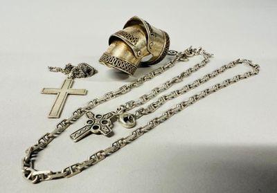 a cross, a bell, and a chain on a table