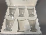 four glasses in a box that are sitting on a table