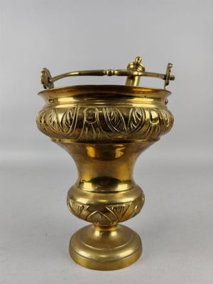 une image représentant un vase doré muni d'une anse, sur fond blanc