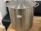 a large stainless steel pot sitting on top of a wooden table