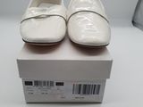 pair of white shoes sitting on top of a box on a table