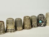 several thimbles are lined up in a row on a white surface
