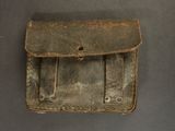 an old brown leather case with two compartments on a table
