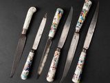 six different types of knives are lined up on a black surface