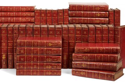 plusieurs livres rouges empilés les uns sur les autres sur une surface blanche