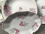 two plates with flowers are sitting on a table next to each other