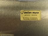 a metal object with a sticker on it that says atelier - muno
