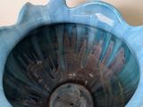 a blue vase sitting on a table with a tag on it