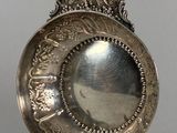 plat en argent sur un socle, surmonté d'anges