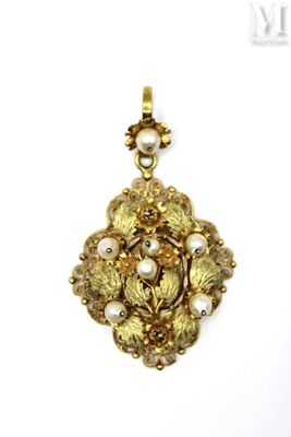 a close up of a gold and pearl pendant on a white background