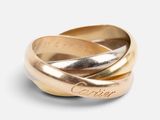 a close up of two gold rings on a white surface