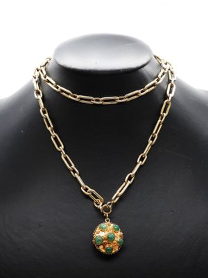 un collier composé d'une chaîne en or et d'un pendentif en pierre verte