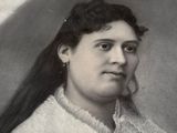 portrait of a woman with long black hair and a white collared shirt