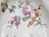 a white plate with flowers and butterflies on it