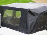 a black cover on the top of a white jeep