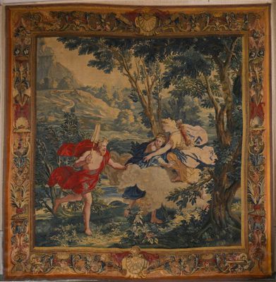 une tapisserie accrochée au mur d'une pièce où se trouve un tableau