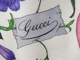 a close up of a floral print shirt with the name gucci on it