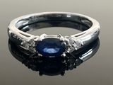 an image of a sapphire and diamond ring on a black surface