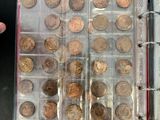 a person holding a binder with a bunch of coins in it
