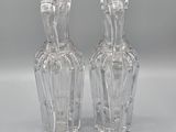 pair of clear glass vases sitting on top of a white surface