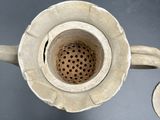 underside view of a metal teapot with a hole in the middle
