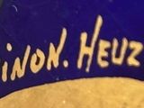 a close up of a blue and white sign that says pinon heuze