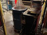 a machine that is sitting in a garage next to a trash can