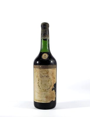 une vieille bouteille de vin posée sur une surface blanche