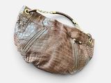 the brown crocodile skin purse is sitting on a white surface